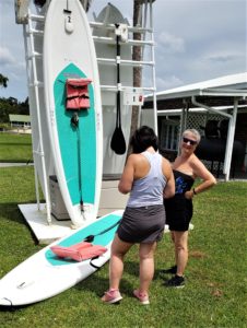 Two women renting paddleboards using PADL technology