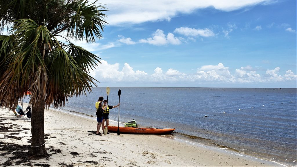 Kayaker holding paddle, getting ready to get into a rented kayak