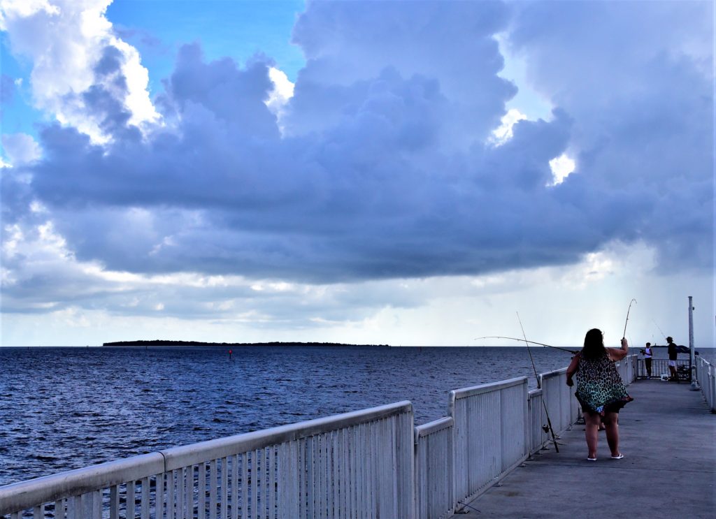 People fishing from the Cedar Key fishing pier, late afternoon, heavy cloud cover