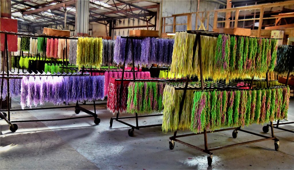 colorful lures hanging on drying racks in factory