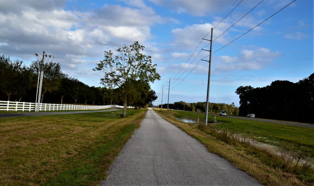 View of one of the paved Rails-to-Trails alongside the highway with cars passing by