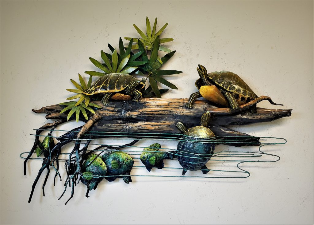 The finished wall hanging of turtles climbing on the log