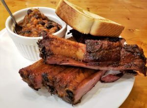 Dinner plate of ribs, baked beans and texas toast