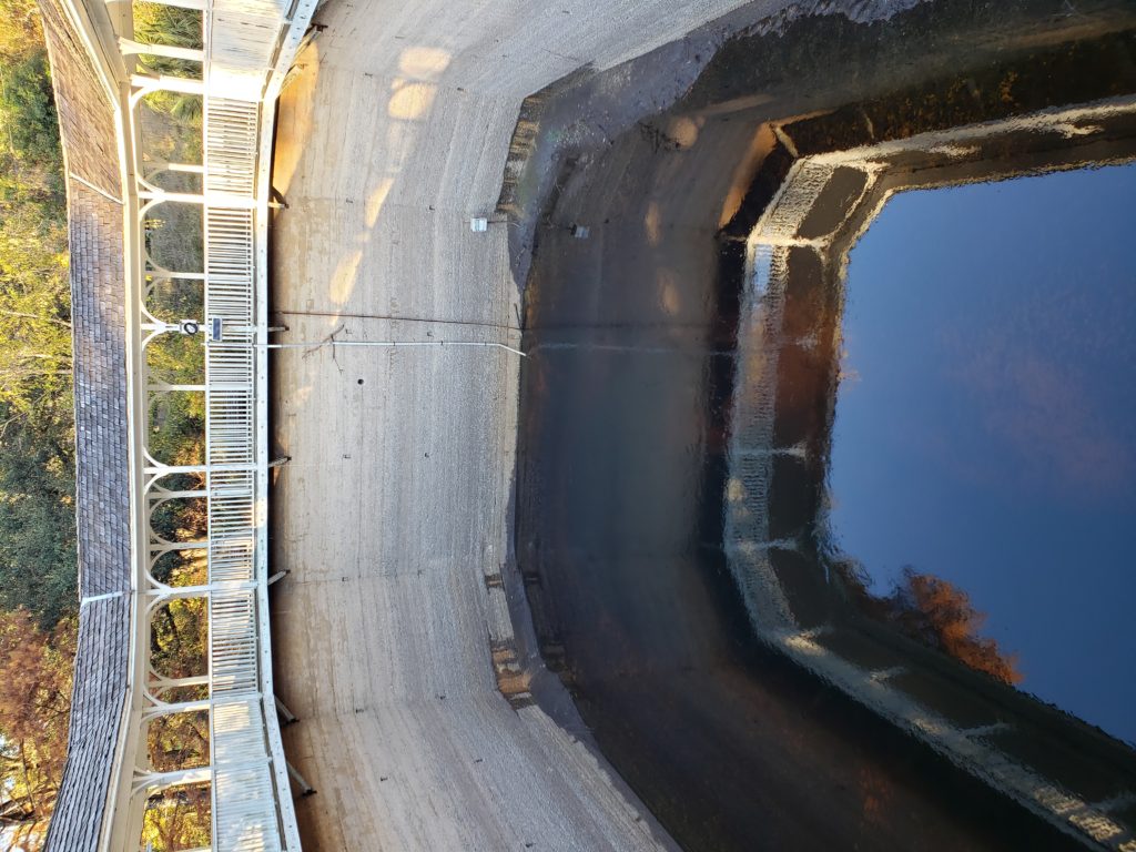 Interior photo of spring. Only top balcony remains. Water in pool reflecting trees and sky