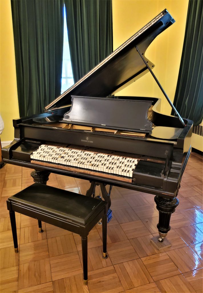 Large baby-grand style piano with 6 rows of keyboards