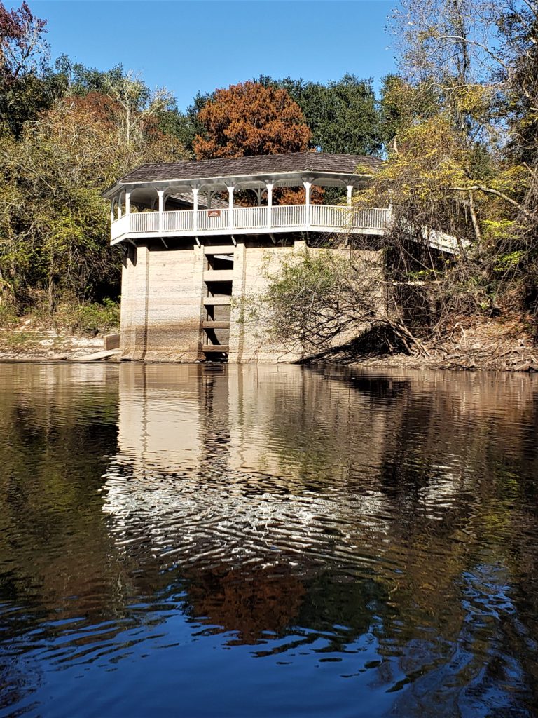 White railing and columns at the top of a large concrete-looking spring house