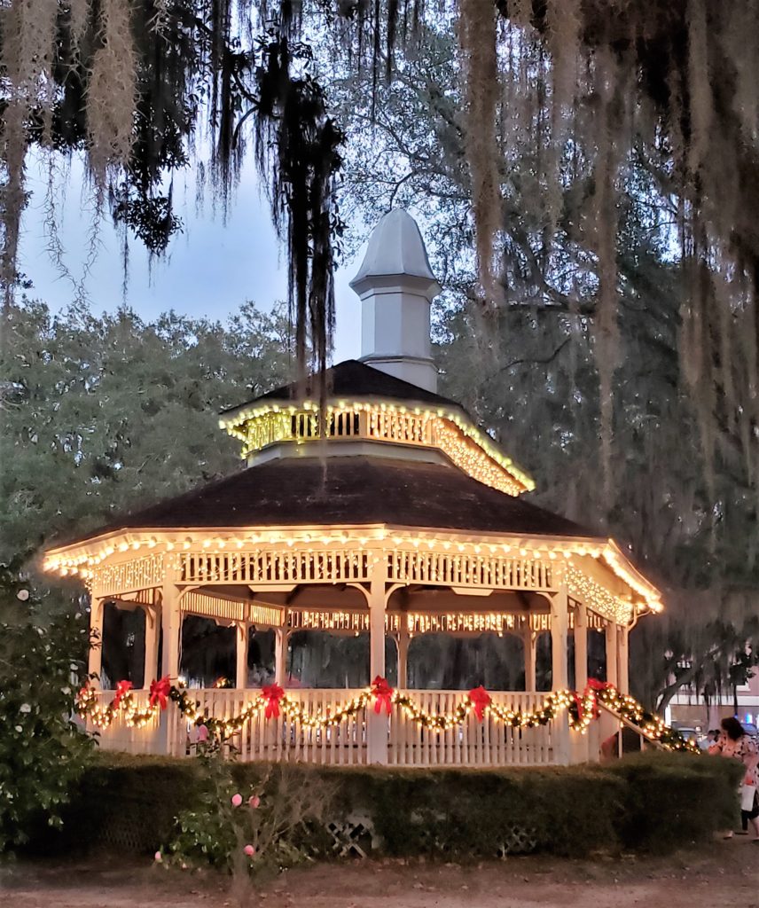 Gazebo in park, with Christmas lights, garland, and red bows