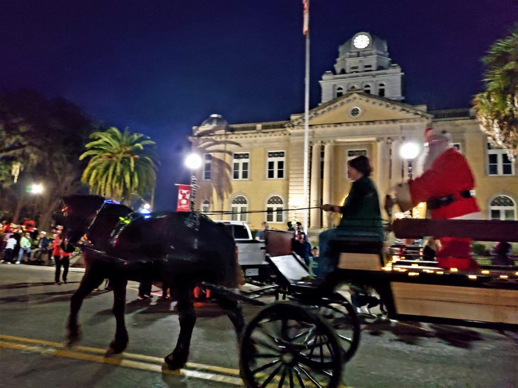 Santa waving from horse-drawn wagon - in front of the historic Courthouse