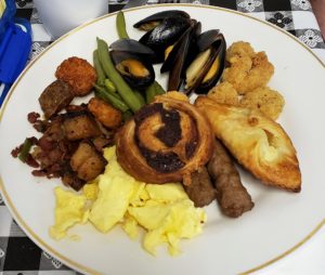 Plate of food - scrambled eggs, hashbrowns, mussells, cinnamon roll