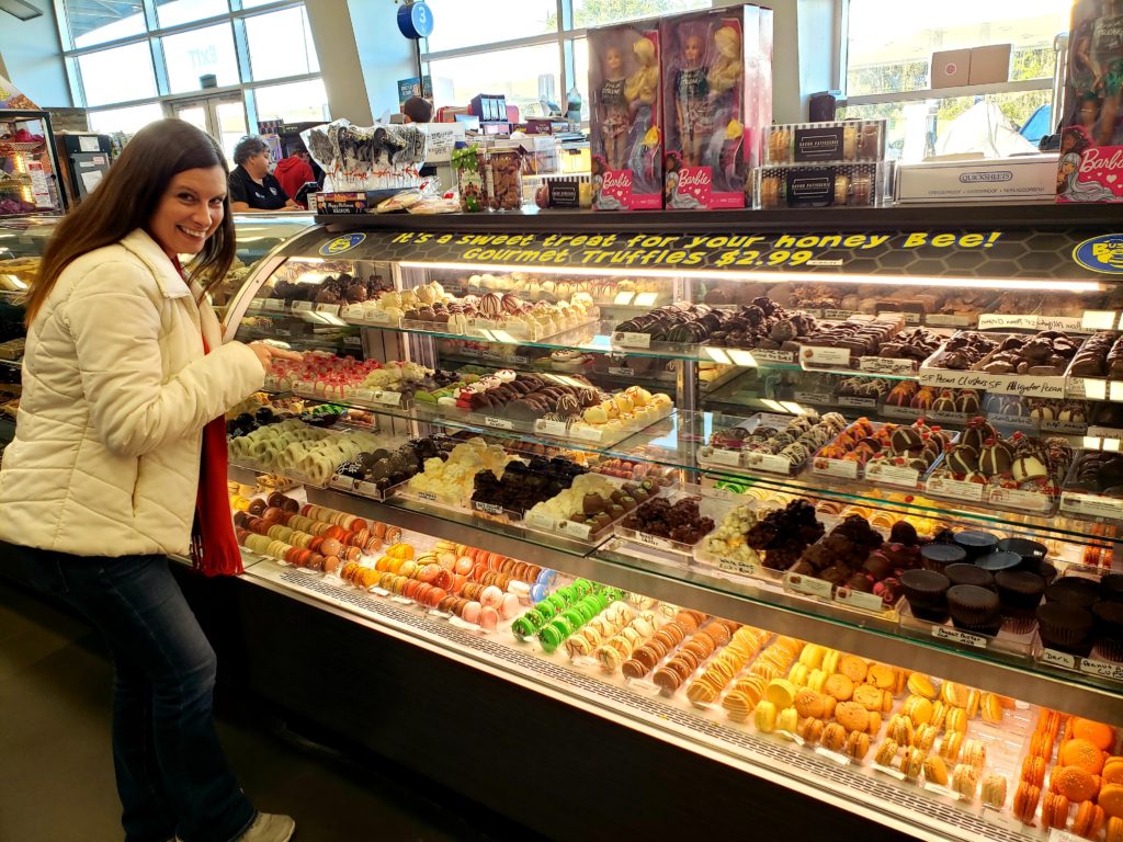 Lady pointing out  her selection of chocolate treats in a glass display case