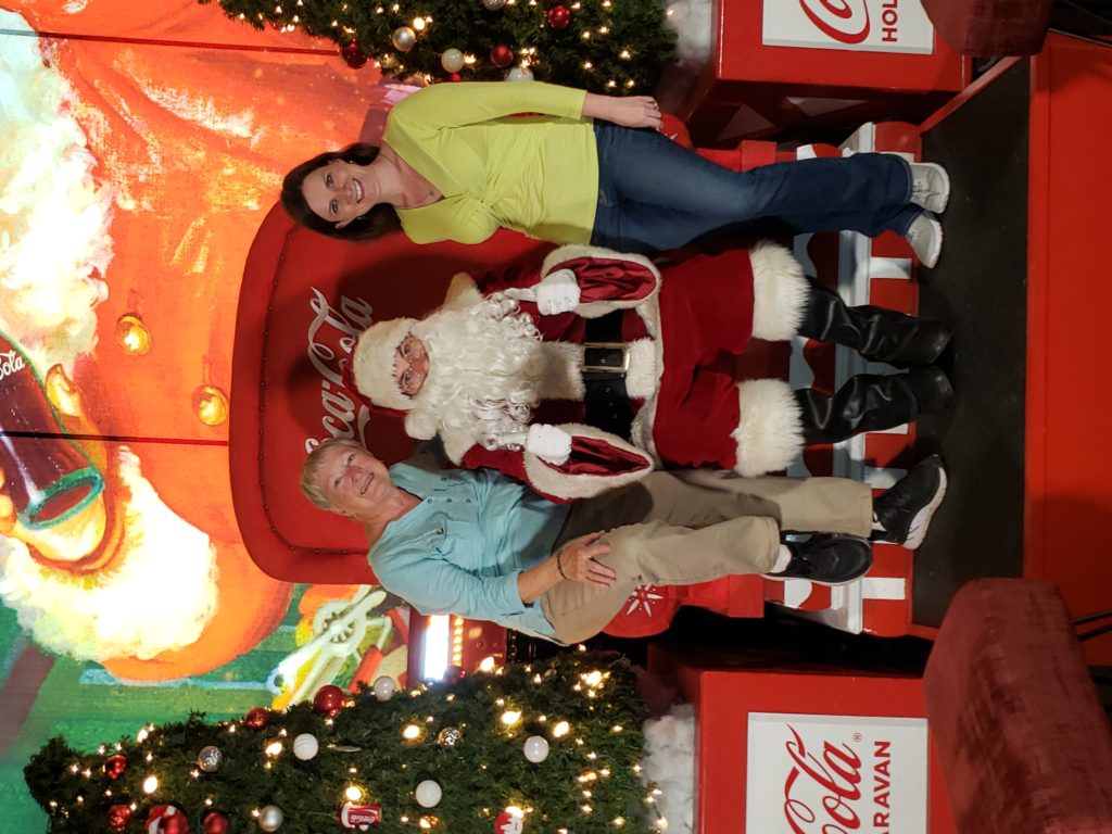 women sitting on each side of Santa