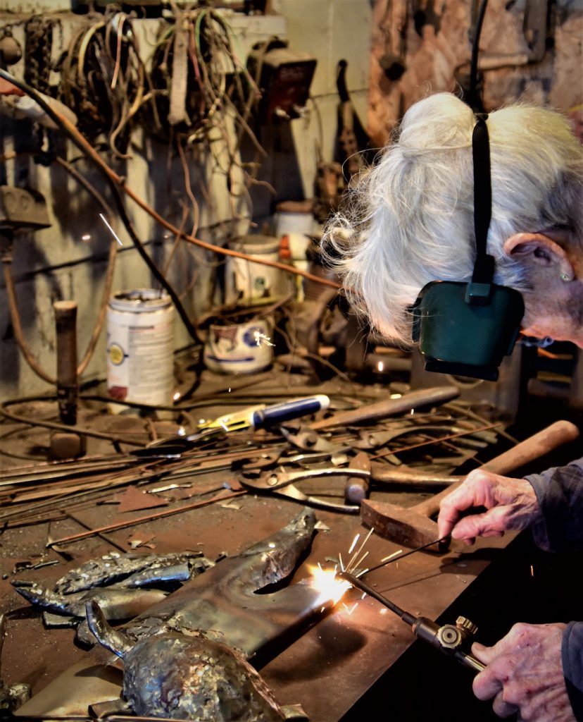 Woman wearing goggles, welding with sparks flying