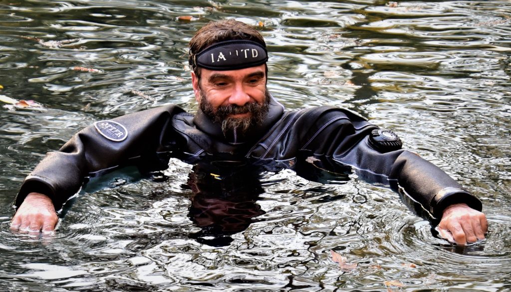 man in scuba suit surfacing water