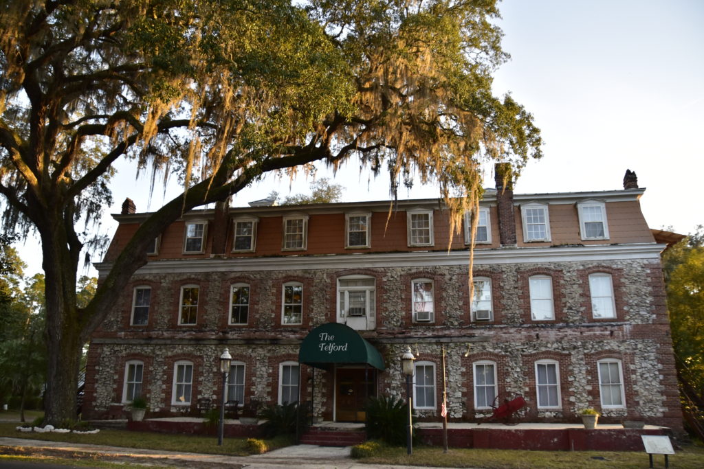 large brick hotel with hip roof, canons on front lawn big oak tree with Spanish Moss. I'm sure there are undiscovered ghosts looking out!
