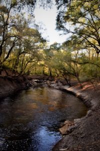 River flowing into pool at sunset